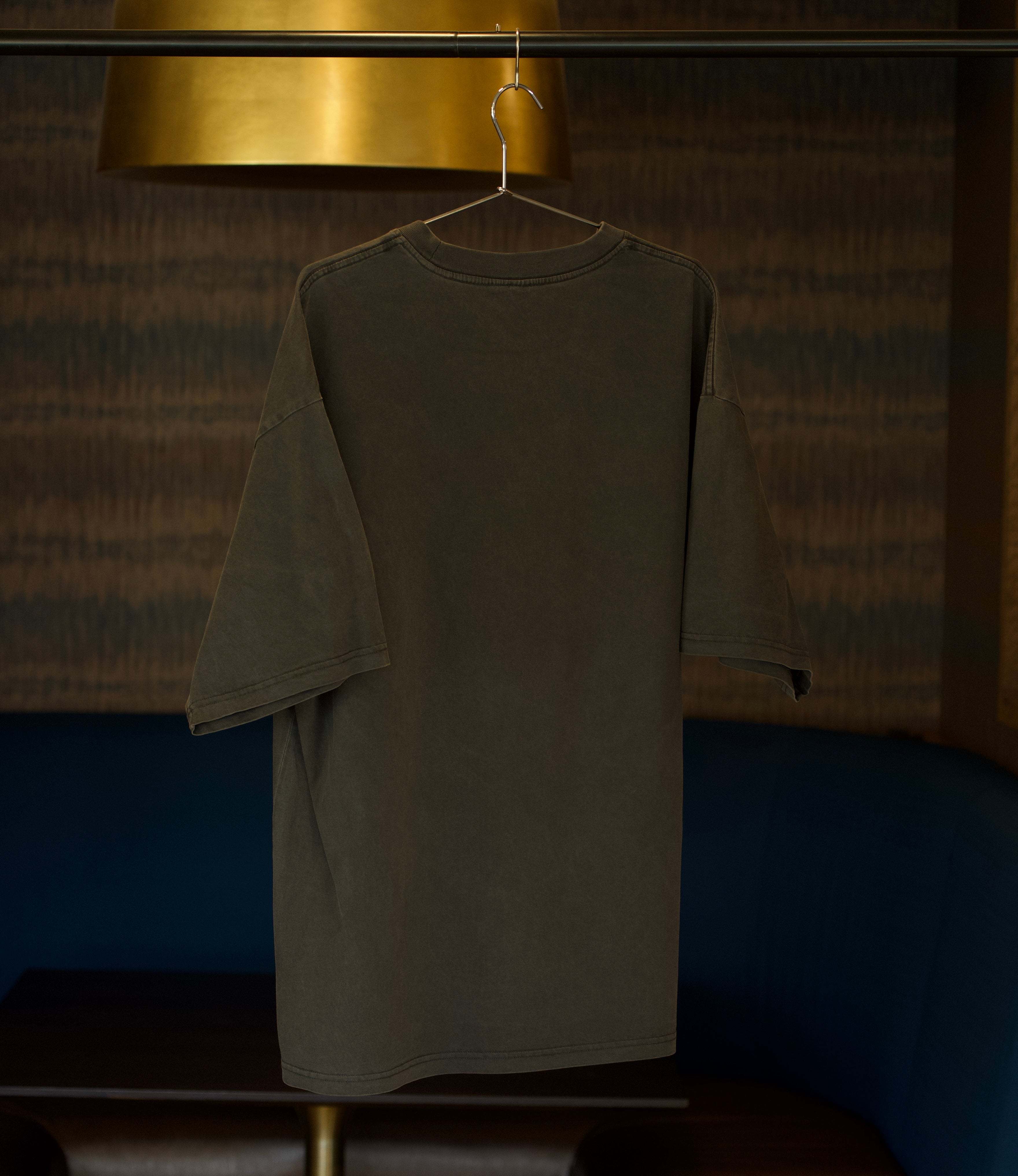 A washed black shirt blank on a hanger.