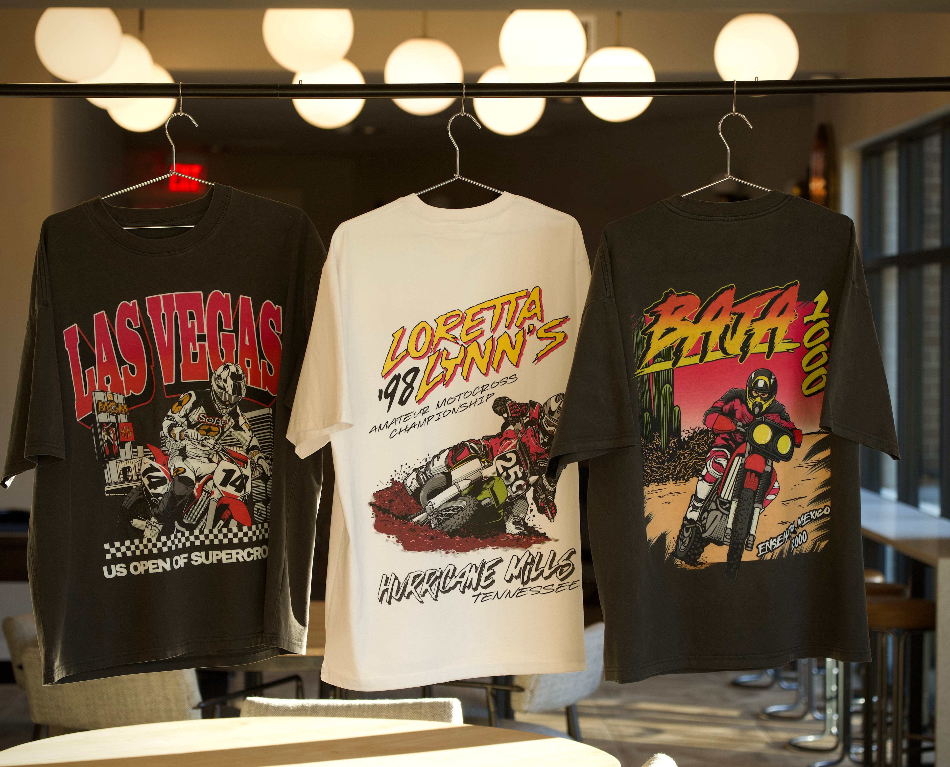 Vintage style motocross, supercross, and off road racing shirts on a hanger.