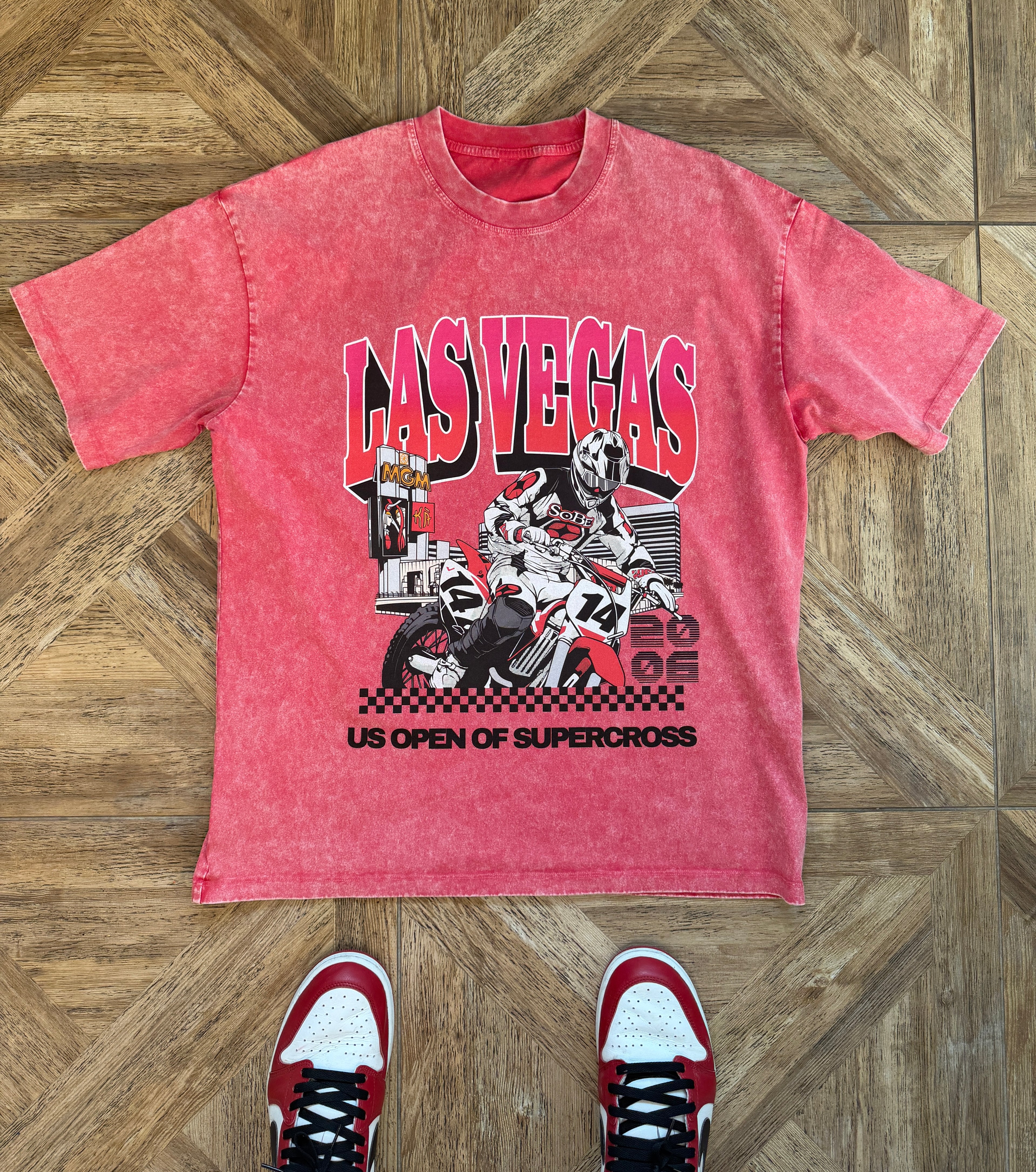 Red t-shirt with 'Las Vegas US Open of Supercross' graphic on a wooden floor.