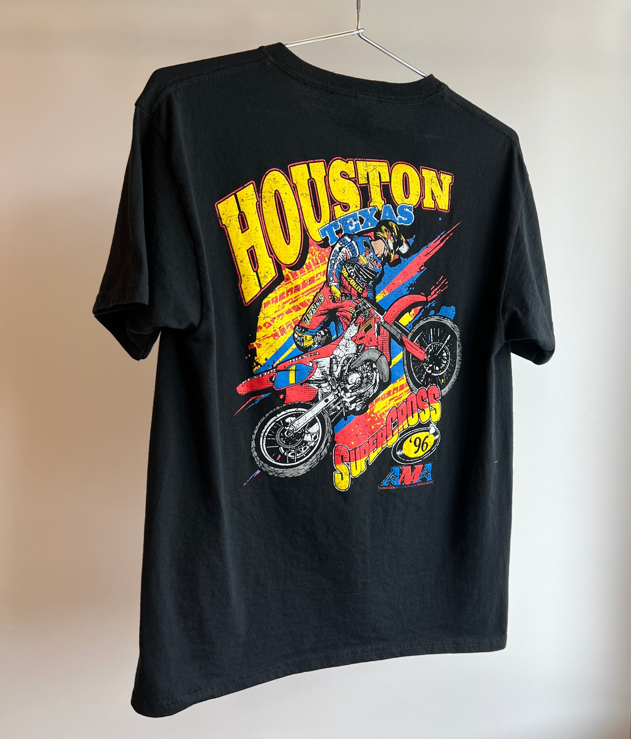 A black youth-sized t-shirt featuring a colorful graphic of a motocross rider with the text 'Houston Supercross' and the name 'Jeremy McGrath'.